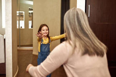 Delighted little girl running to hug her grannyの写真素材