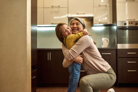 Happy granny with grandchild embracing at homeの写真素材