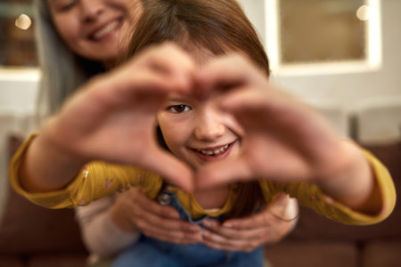 Sweet girl holding hands in heart shapeの写真素材