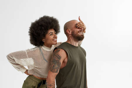 Black woman covering eyes of male friend