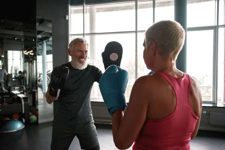 Engaging boxing trainer teaches woman to self-defenseの写真素材