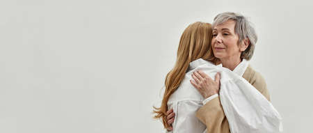 Loving old mother hug support grownup daughterの写真素材