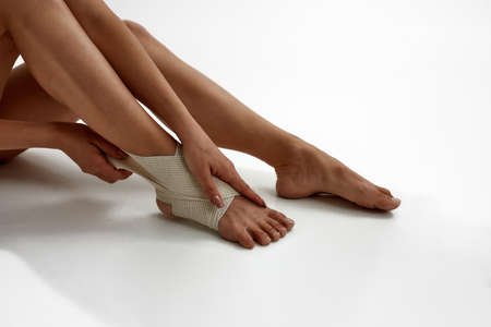 Partial of dancer putting elastic bandage on legの写真素材