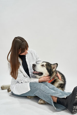 Girl embracing and looking on Siberian Husky dogの写真素材