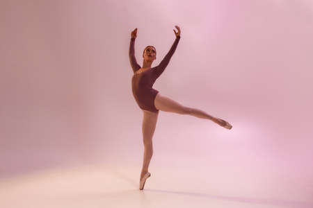 Girl dancing ballet on bright pink backgroundの写真素材