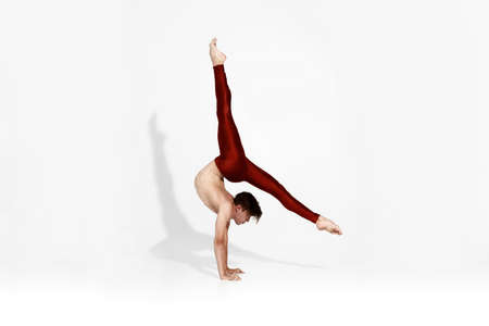 Young caucasian male dancer standing on hands