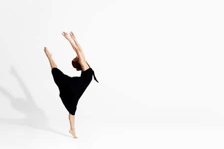 Caucasian ballerina in dress dancing in studioの写真素材