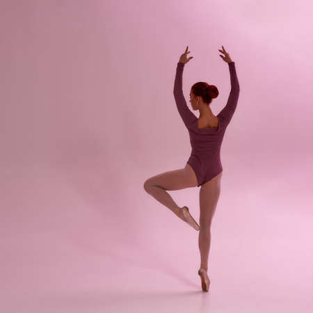 Back view of girl dancing ballet dance in studio