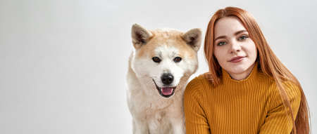 Caucasian girl and Shiba Inu dog looking at cameraの写真素材