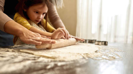 One little girl rolling out dough with rolling pinの写真素材