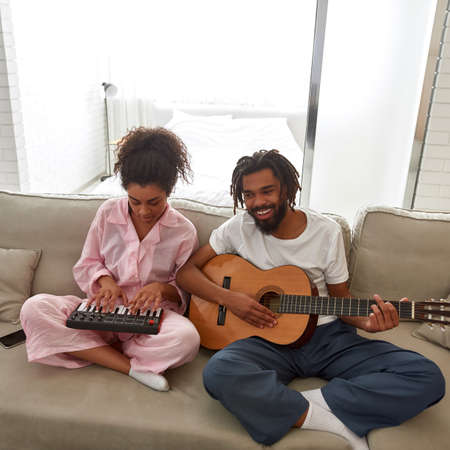 Man and woman play on musical instruments at home