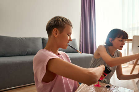 Lesbian girls painting with pink and purple paints