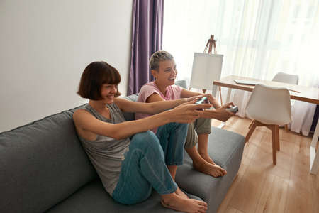 Young cheerful lesbian girls playing video gameの写真素材