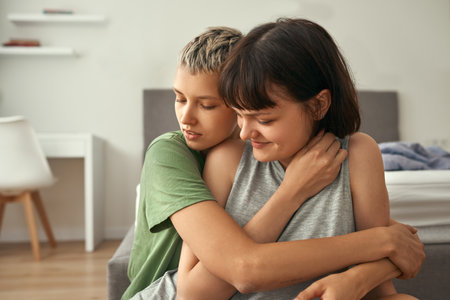 Young lesbian couple resting and hugging at homeの写真素材