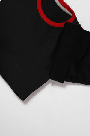 Cropped shot of folded black cotton long sleeve and beanie hat isolated over white backgroundの写真素材