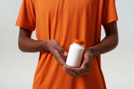 Cropped of black man hold jar with medical pills