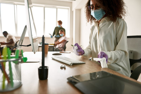 Curly girl apply sanitizer for wiping PC keyboard