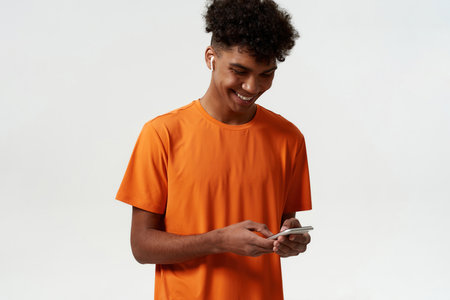 Black man in wireless earphones type on smartphone