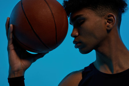 Black pensive sports man hold basketball ballの写真素材