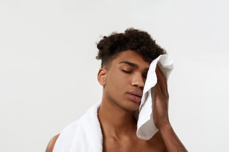 Black tired sportsman wiping face with towelの写真素材