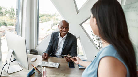 Smiling black male boss take report from employee