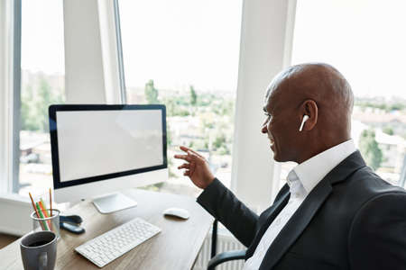 Smiling black business man watching on computerの写真素材