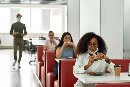 Multiracial employees eating at lunch at officeの写真素材