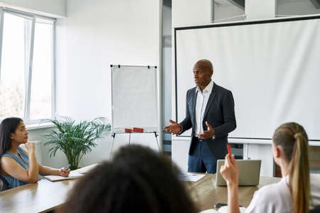Embarrassed black boss looking at female employeeの写真素材