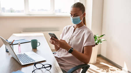 Young caucasian girl use smartphone while working