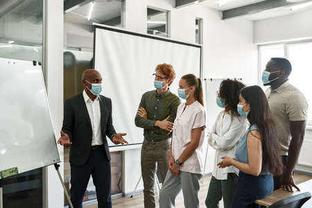 Employees look on leader tell at interactive boardの写真素材