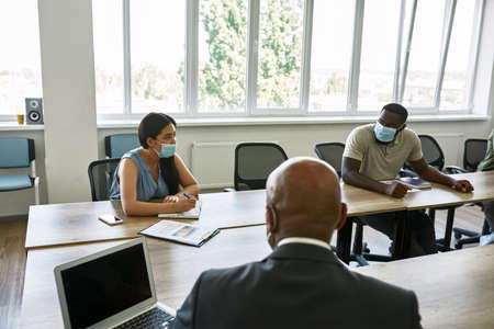 Boss and employees looking on woman at meetingの写真素材