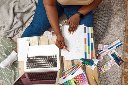 Cropped of female designer drawing clothing model