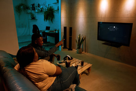 Black man point with finger on TV-set for girl