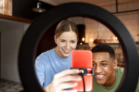 Woman push on smartphone at make video with man