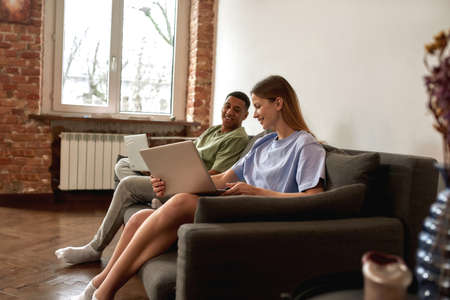 Woman showing on laptop to her black boyfriend