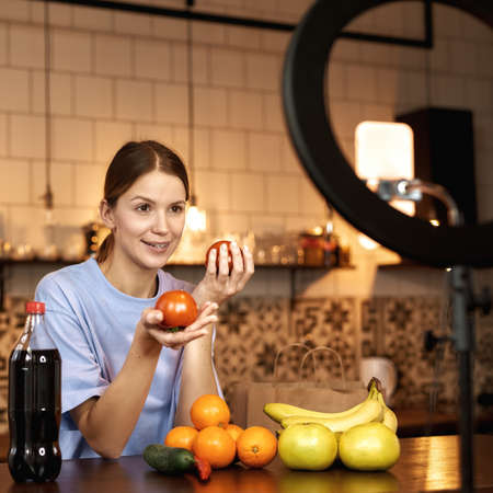 Girl showing tomatoes making cook video challengeの写真素材