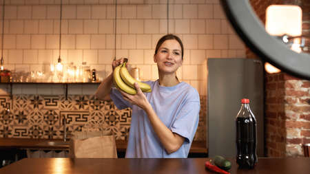 Girl show bananas during make cook video challengeの写真素材
