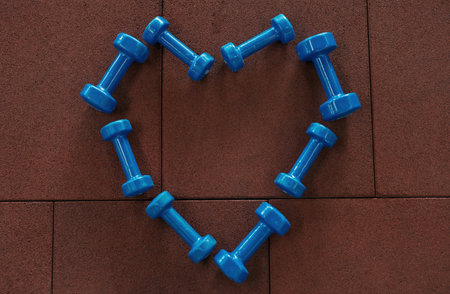 Top view of dumbbells in form of heart in gymの写真素材