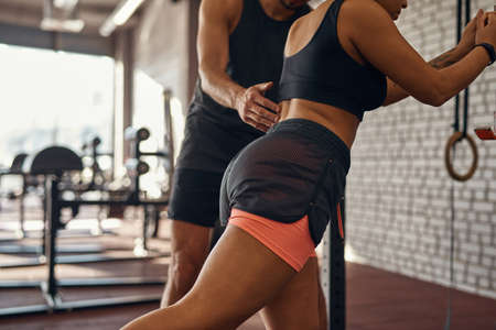Cropped of trainer teaching black girl warming upの写真素材