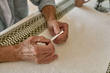 Cropped image of mature male hands hold cigaretteの写真素材
