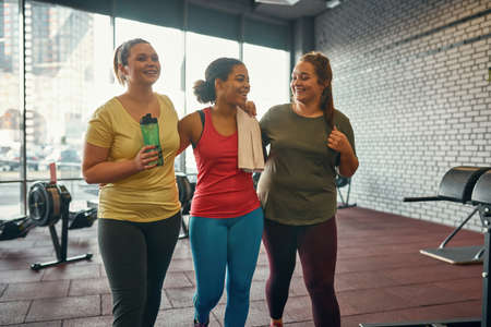 Joyful girls hugging and going after trainingの写真素材