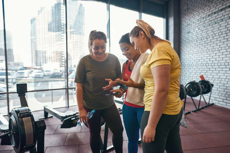 Girls watching sport app on smartphone and talkingの写真素材