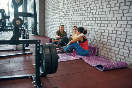 Caucasian girl give smartphone to black girlfriendの写真素材