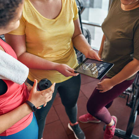 Girls use and watch on sport app on digital tabletの写真素材