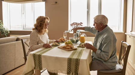Man pouring wine in glass of wife during dinnerの写真素材