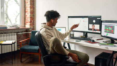 African american trader pointing on data index chart graph during video callの写真素材