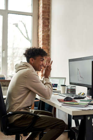 African american stock trader looking at graphs and rejoices