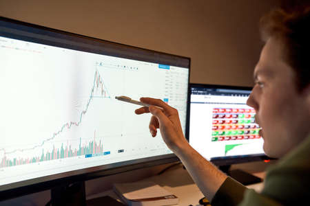 Cropped image of trader watch and point on graphの写真素材
