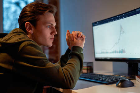 Focused male trader watching stock market graph