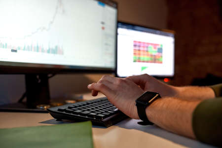 Selective focus of male trader typing on computer